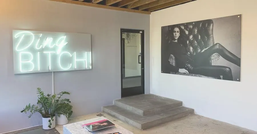 Walker Drawas workspace with custom wall art, dimensional signage, and a neon sign
